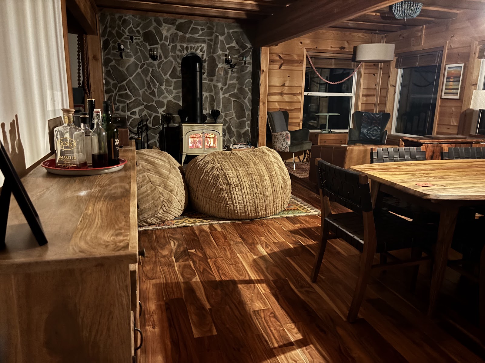 Wood-burning stove glowing beside the cabin dining area