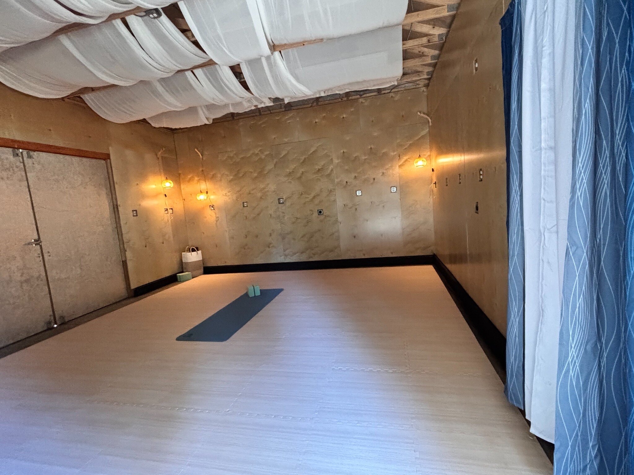 Bright interior of the wellness studio with open floor space and infrared heaters