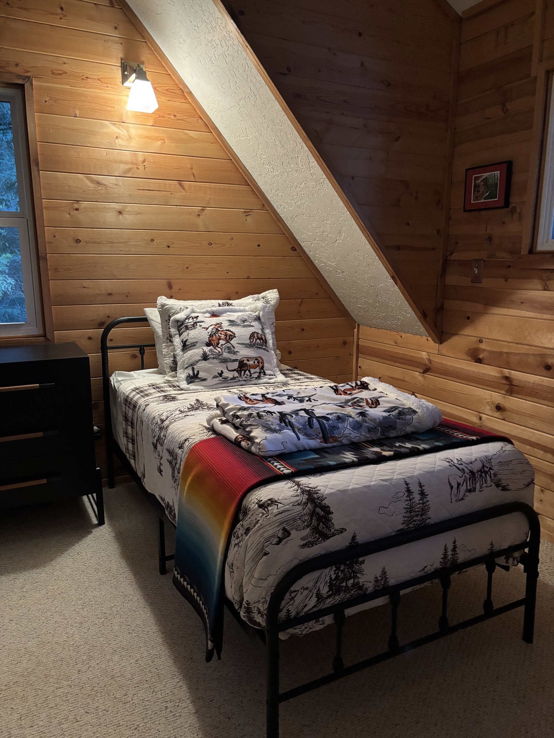 Twin bedroom with Pendleton bedding and warm wood walls